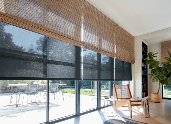the-shade-store-waterfall-woven-wood-shades-artisan-weaves-cove-beige-woven-wood-waterfall-woven-wood-shades-over-roller-shades-chair-hero-image-2021-madison-600x435